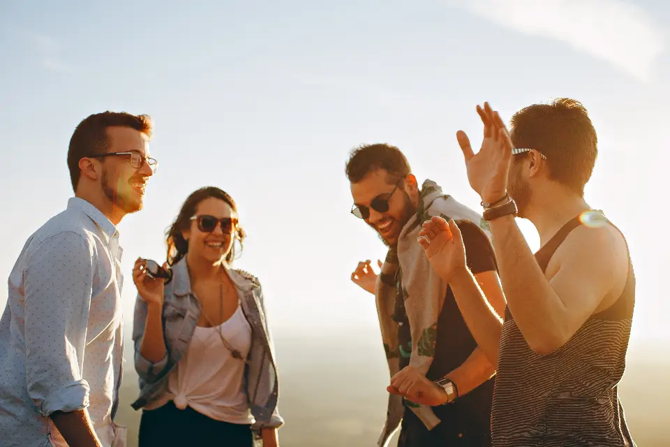 Des amis qui rient ensemble à la tombée du jour