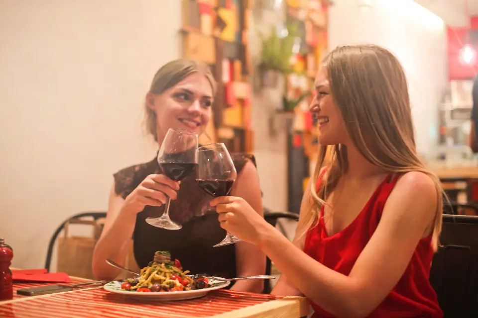 Deux amies qui trinquent au dîner
